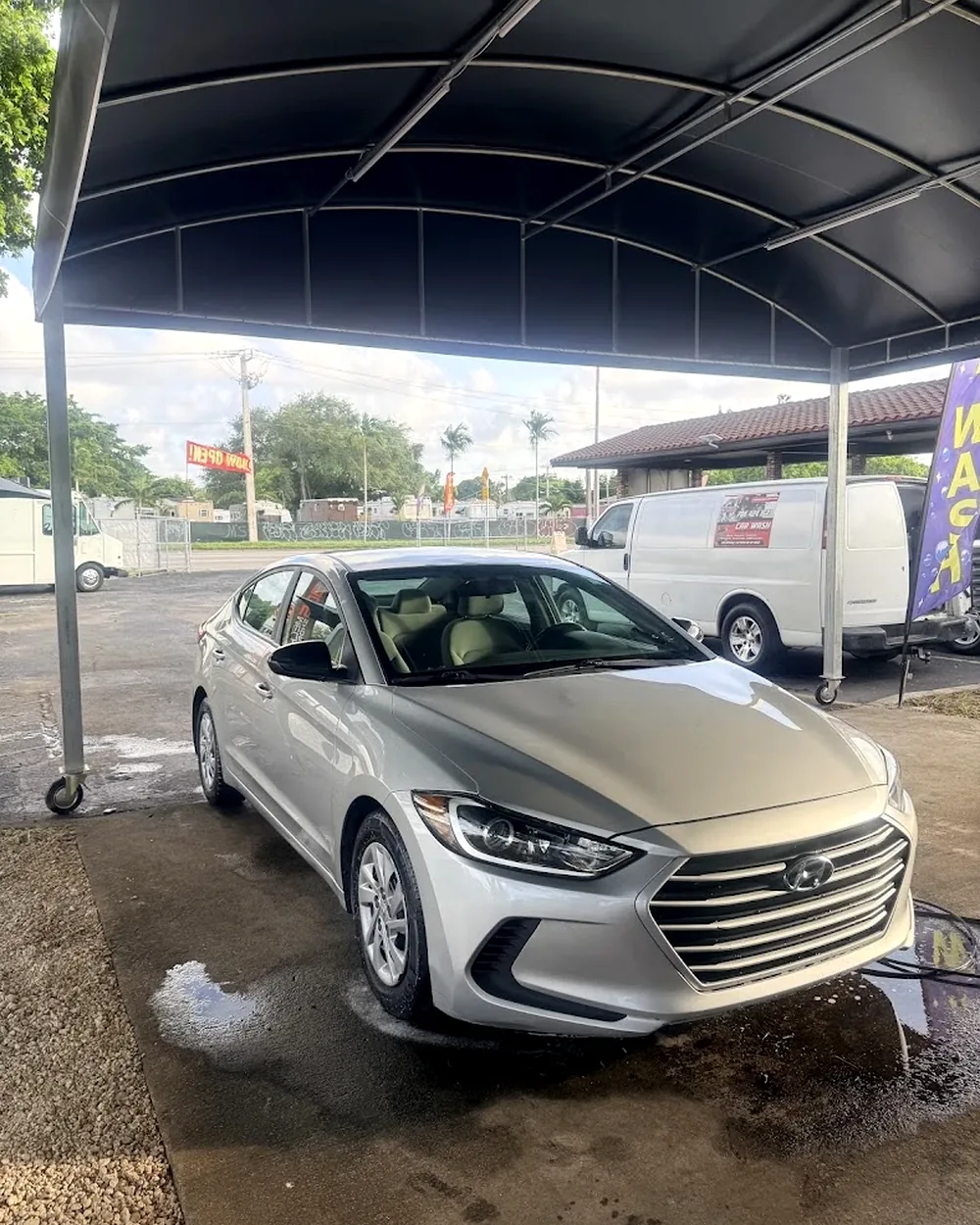 Silver Hyundai sedan freshly detailed inside Michael's Car Wash bay with mobile van behind